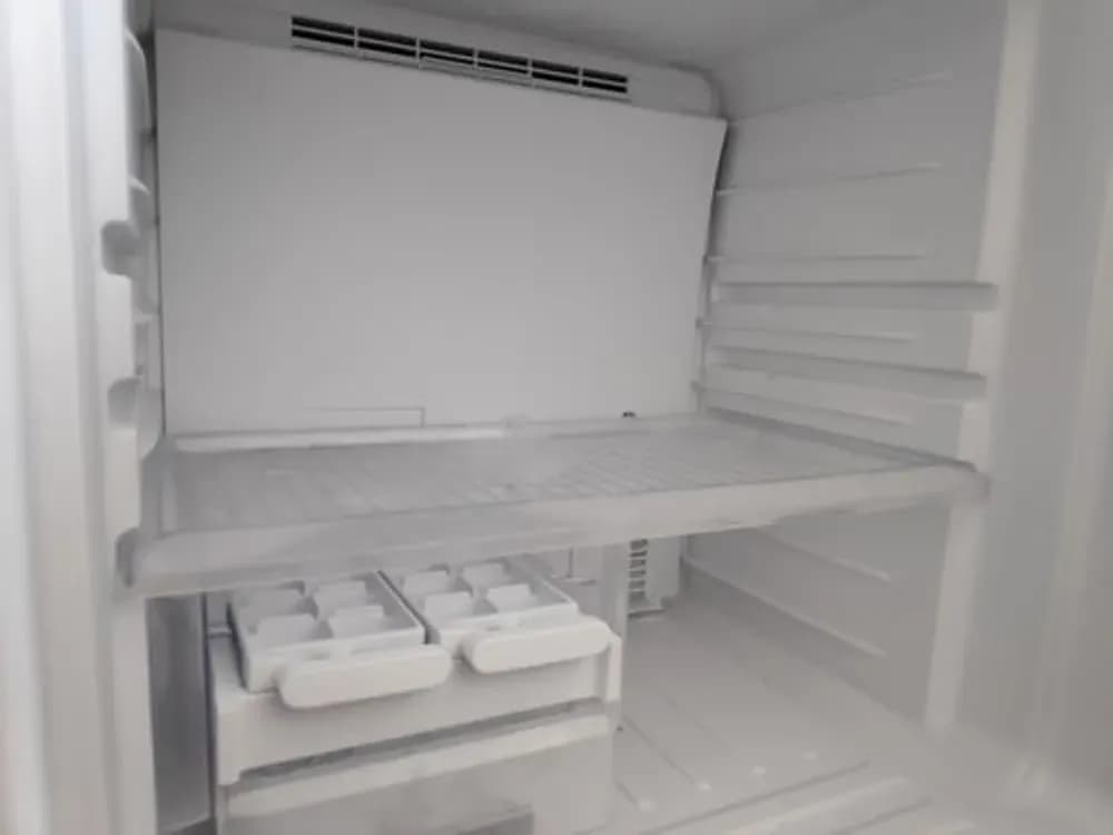 Clean refrigerator interior with washed shelves and drawers after Bright Glow service